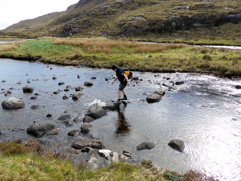 Mike crossing the stepping stones. No bridge! Photo by Mike Goodyer